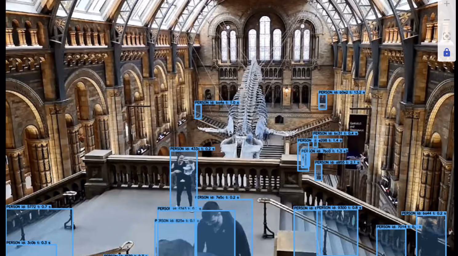 Museum interior with whale skeleton exhibit and multiple people outlined in blue detection boxes.