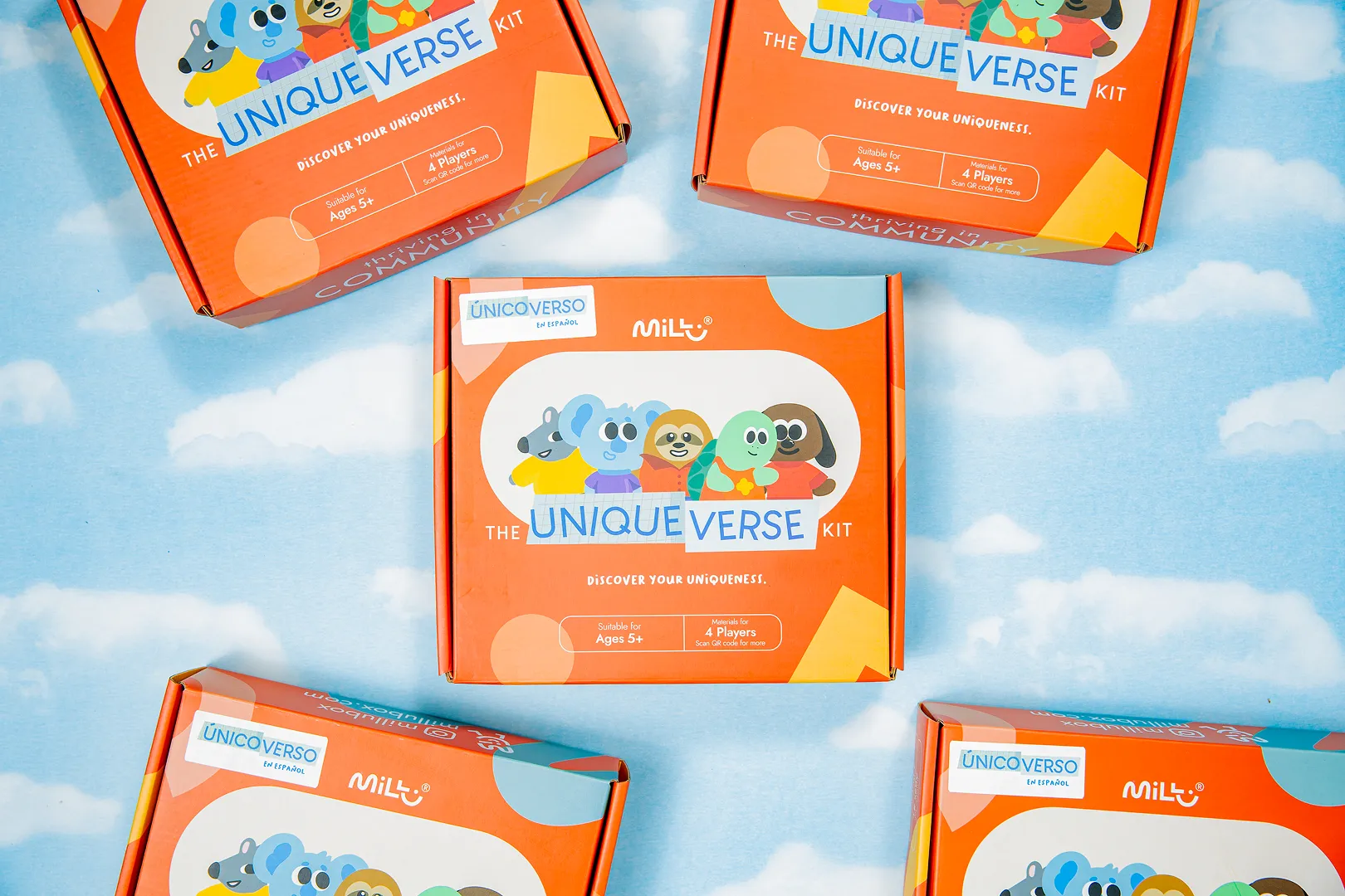 Orange boxes of The Unique Verse Kit with cartoon animal characters, displayed on a blue sky and clouds background.