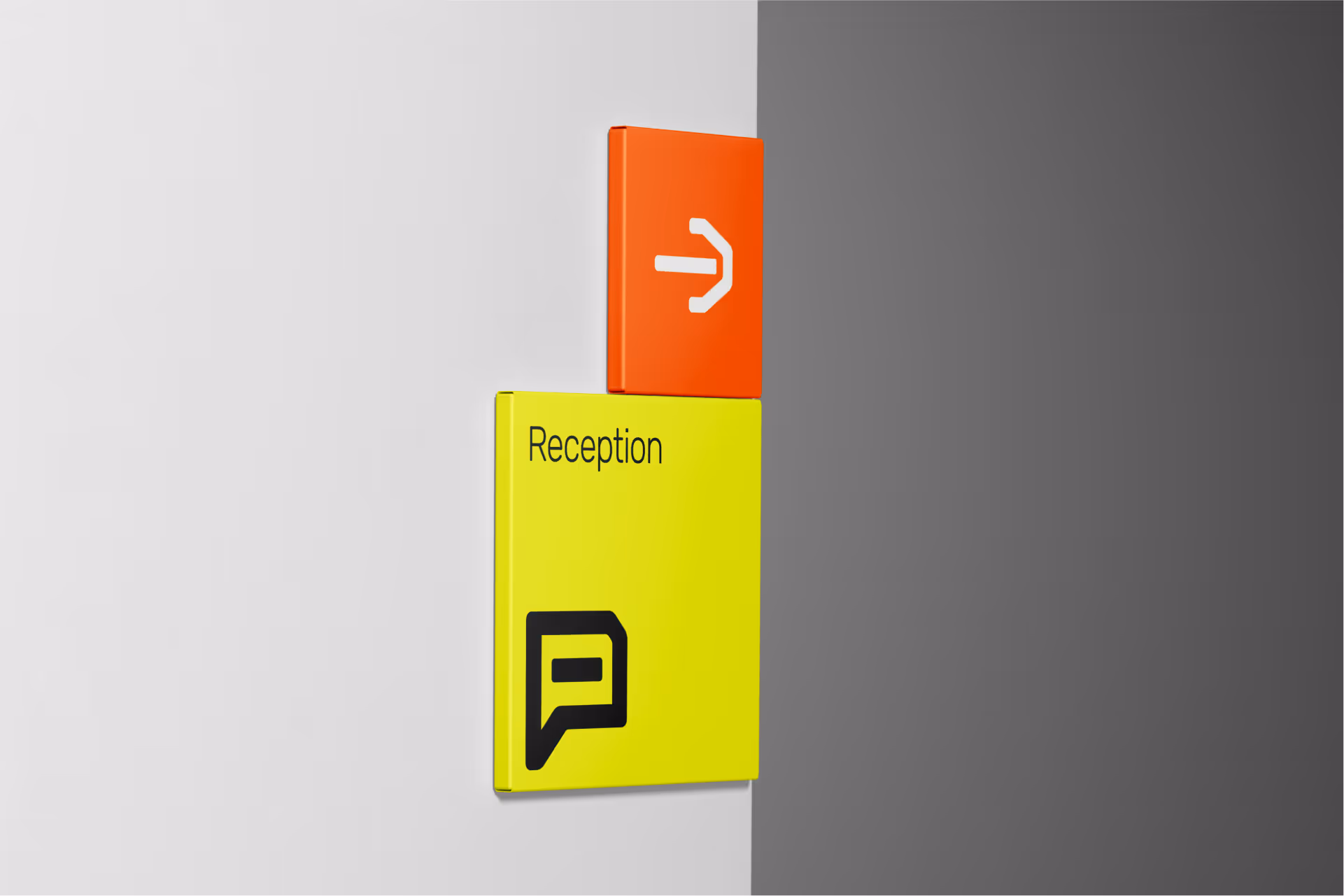 Wall-mounted yellow and orange directional signs indicating 'Reception' with a right arrow.