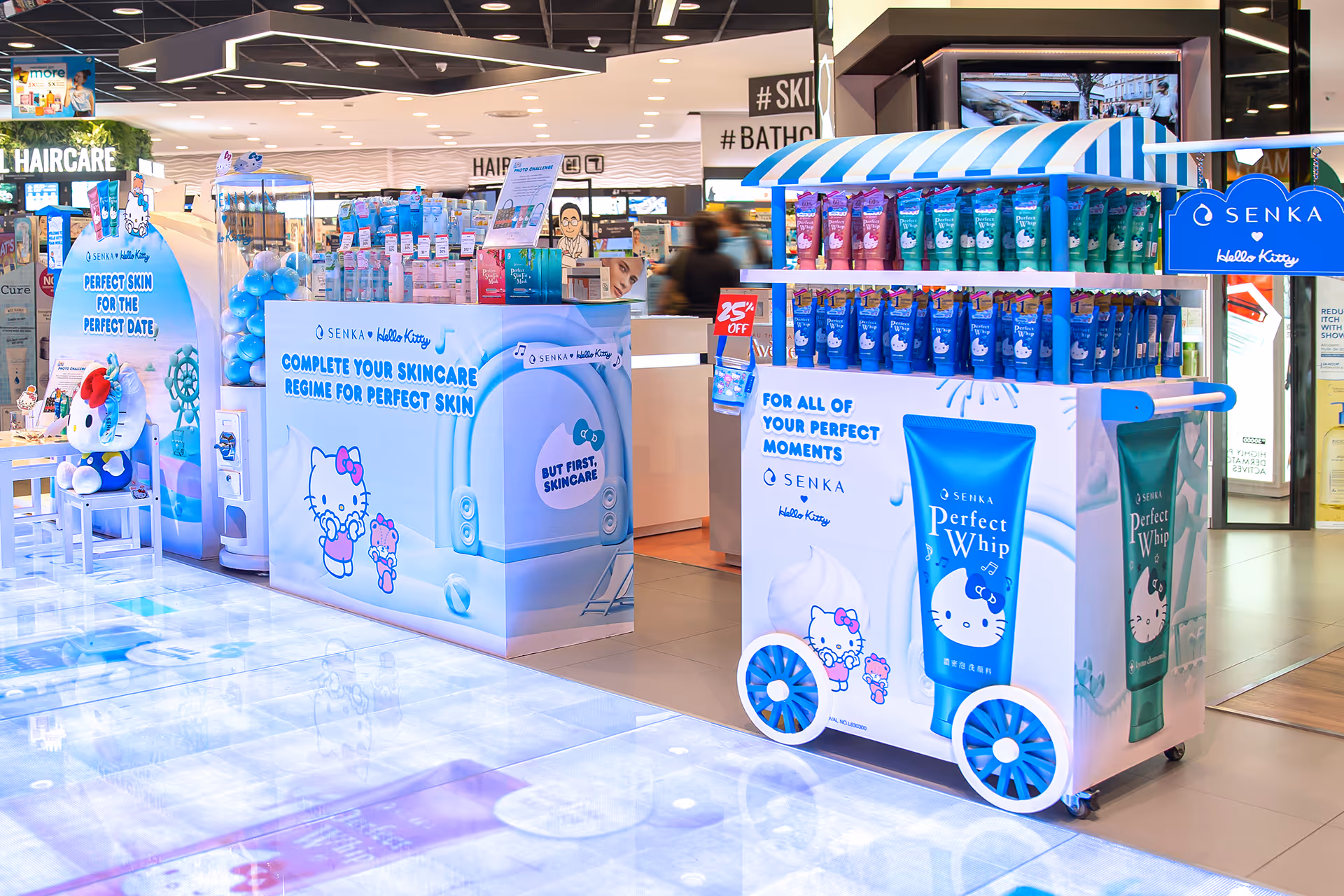 Senka x Hello Kitty skincare product display carts with colorful tubes and Hello Kitty graphics in a bright retail store.