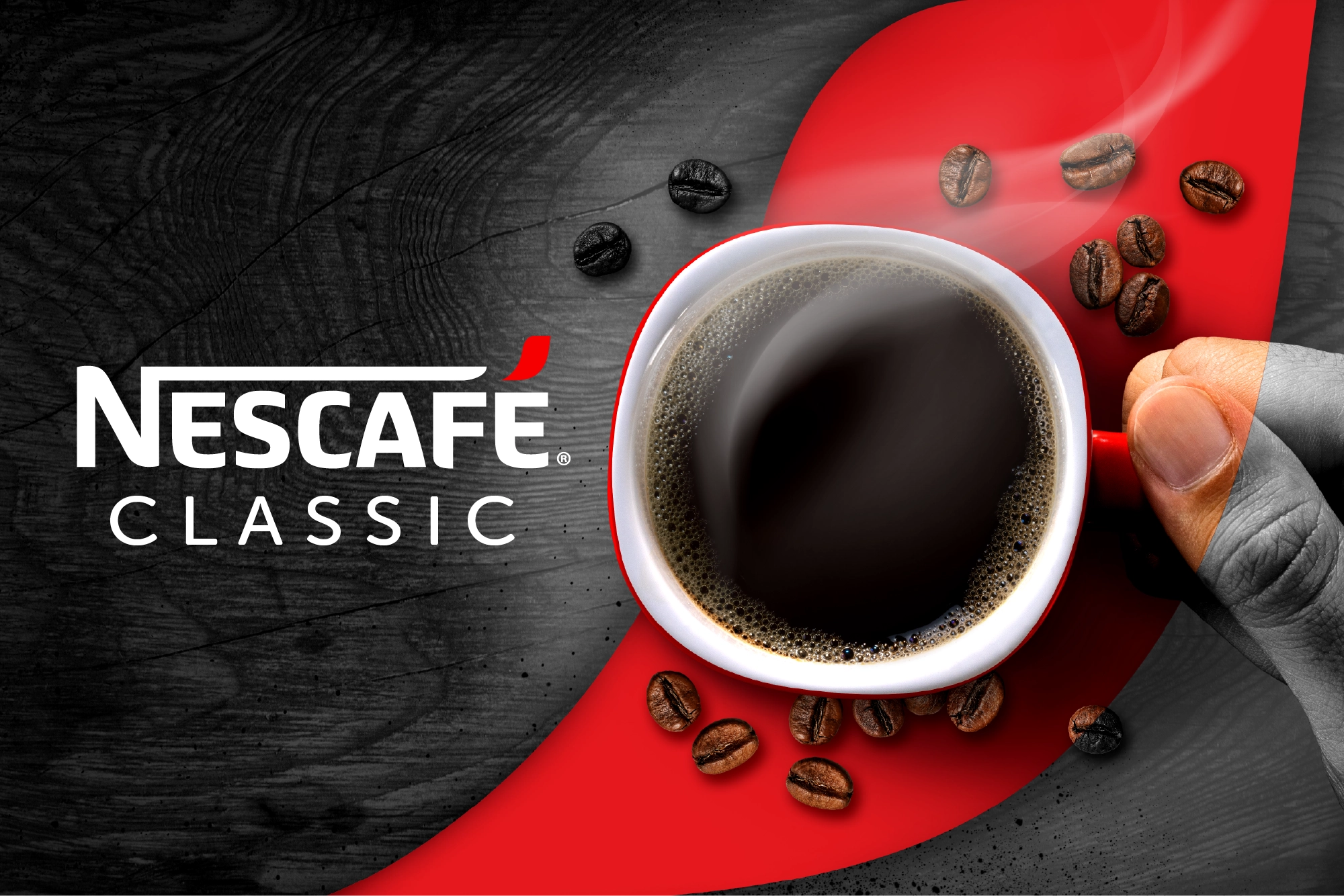 Hand holding a steaming cup of black coffee with coffee beans scattered on a red and black background beside the Nescafé Classic logo.