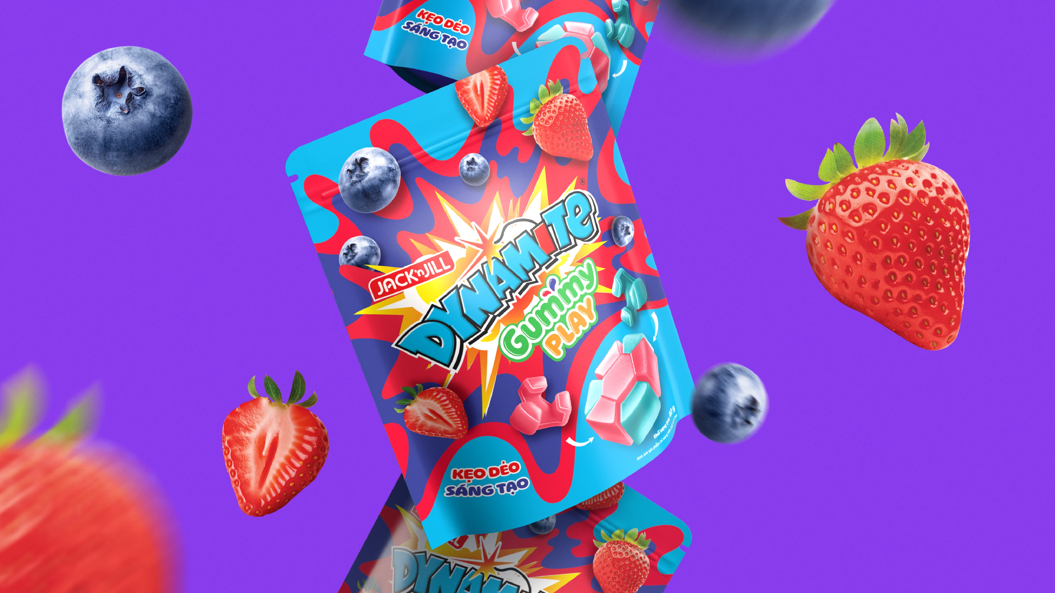 Packaging of Jack ’n Jill Dynamite Gummy Play candy with blueberries and strawberries on a purple background.