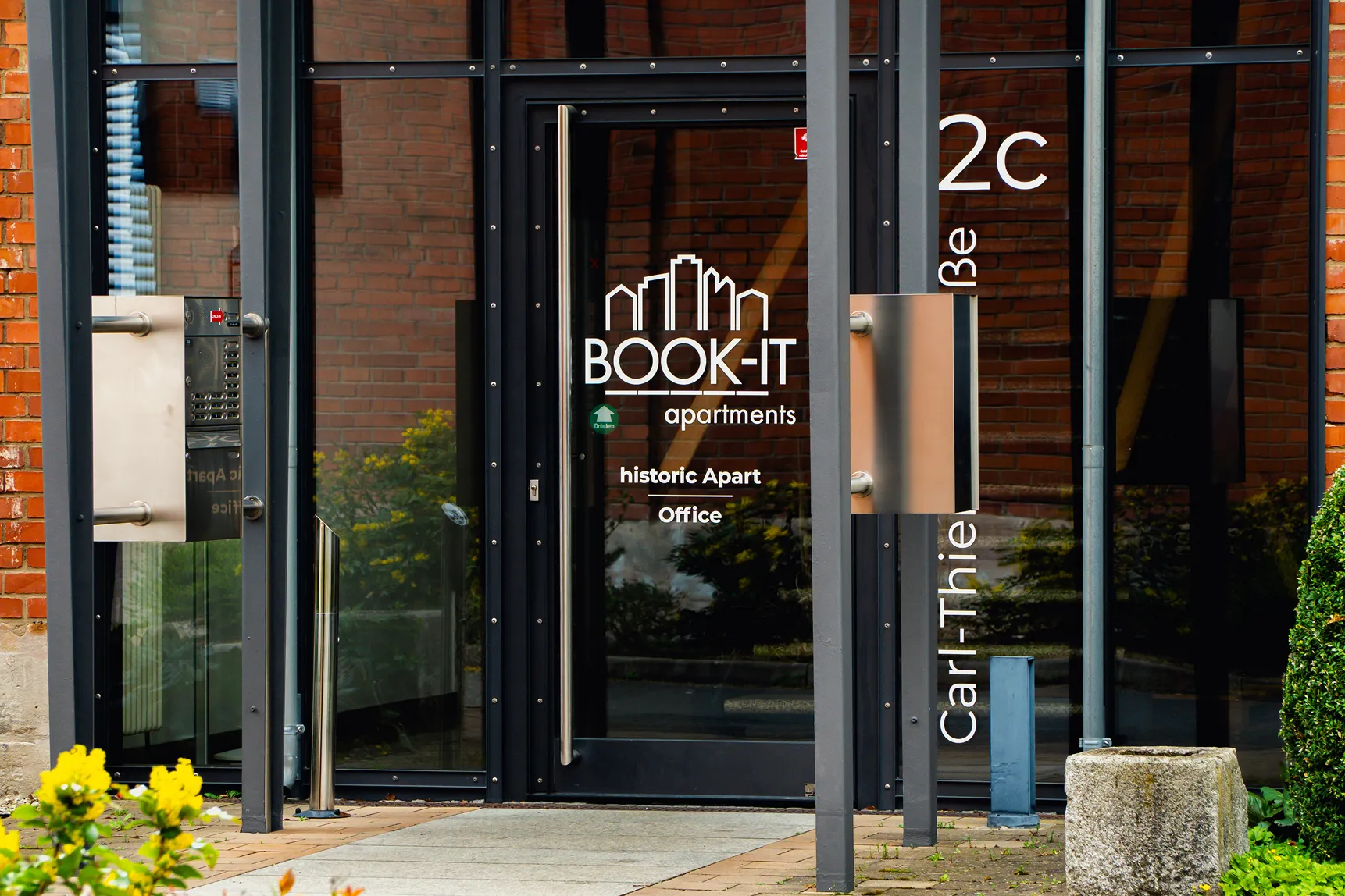 Entrance door to BOOK-IT apartments historic apartment office with intercom system on the side.