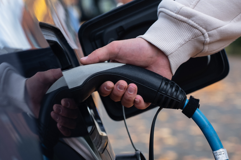 A person pumping gas into a car at a gas pump.