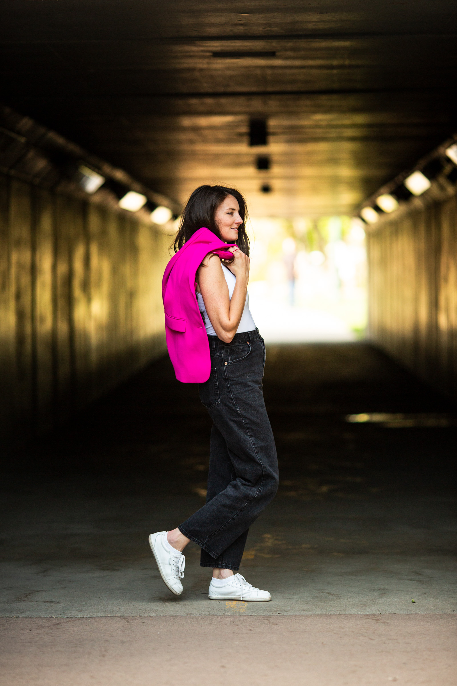 Portrait of Jenève walking just outside a walking tunnel.