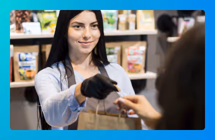 A shop assistant handing a bag to a customer