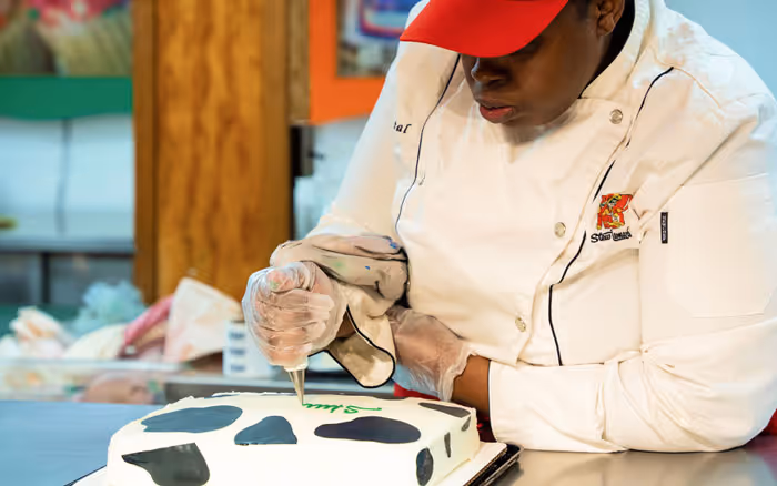 bakery worker drawing a cake inscription