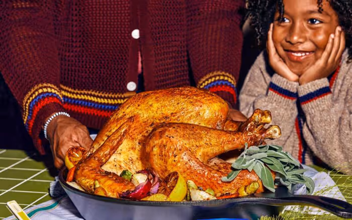 boy looking happy next to a baked turkey