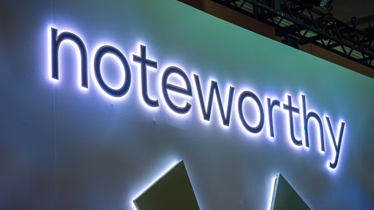 The word noteworthy illuminated in white light on a gray background at an angle.
