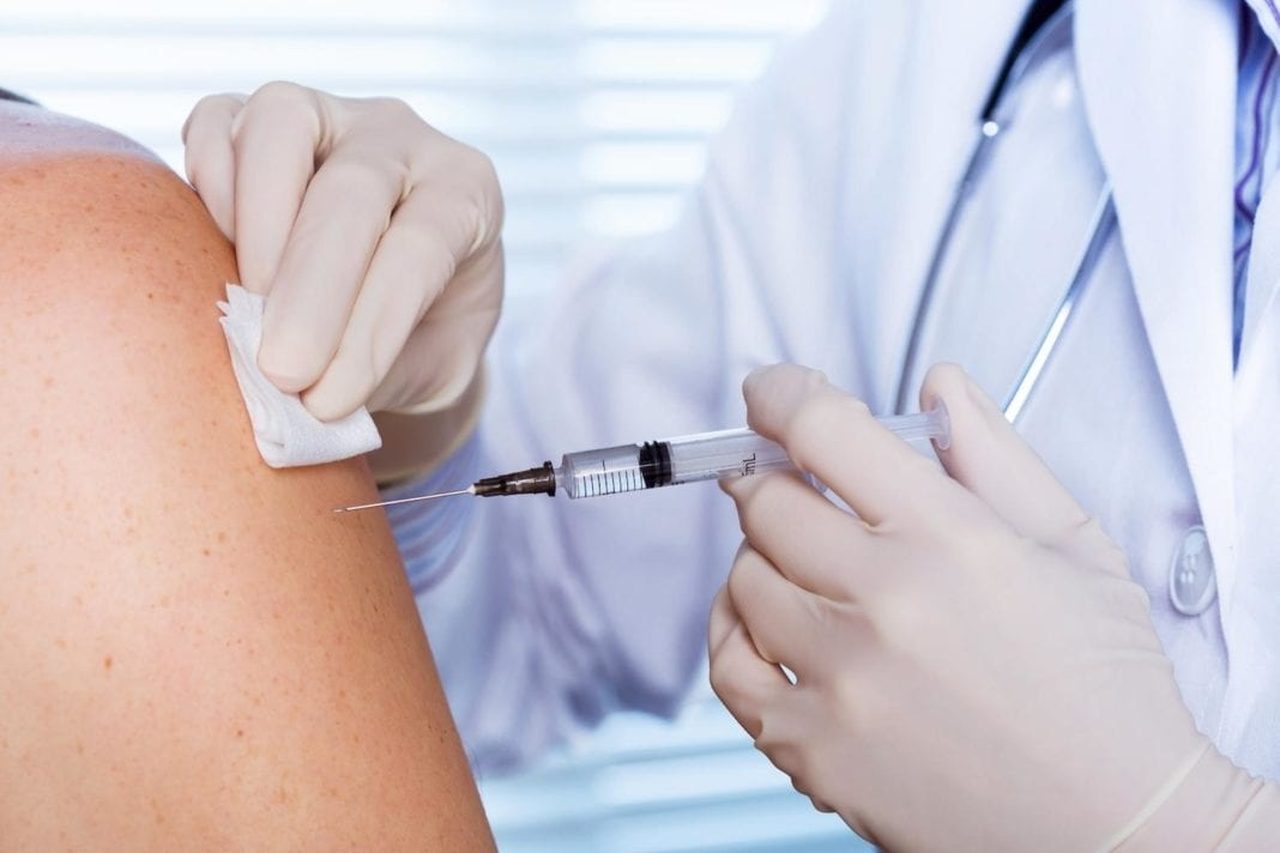 Лікар робить щеплення в плече