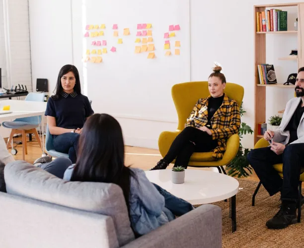 A group of people talking in an office.