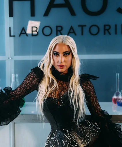 Lady Gaga in front of a glass window.