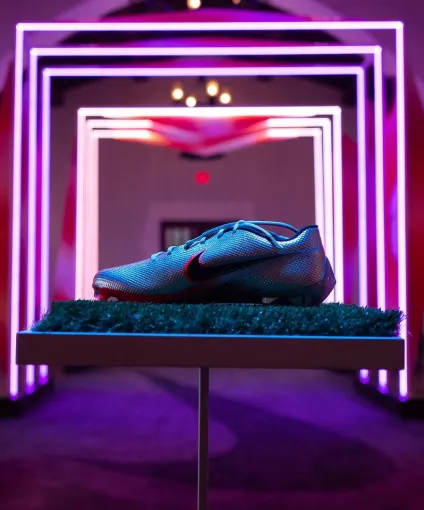 A Nike shoe being showcased with purple lights in the background.