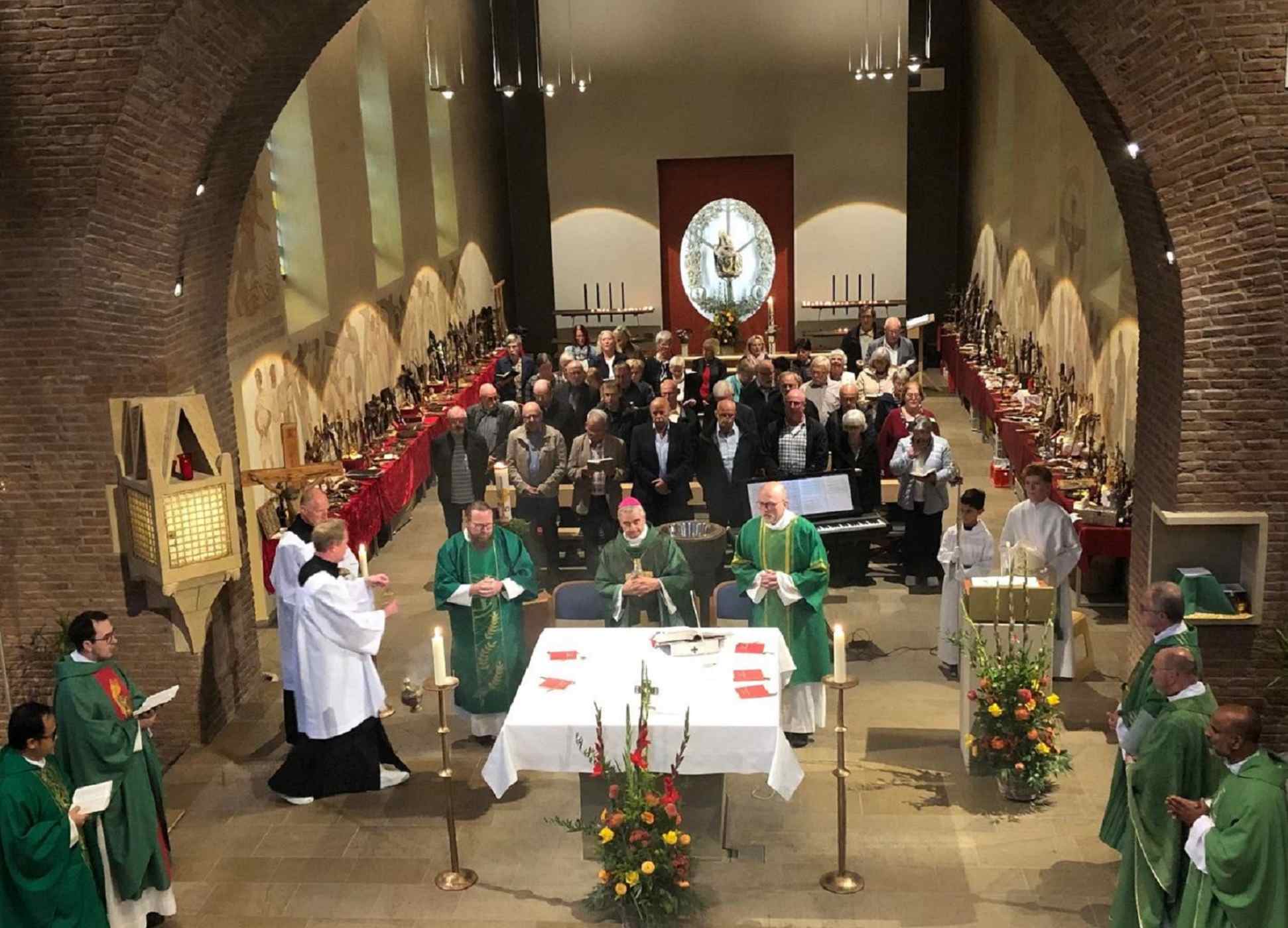 Priester und Gemeinde um den Altar