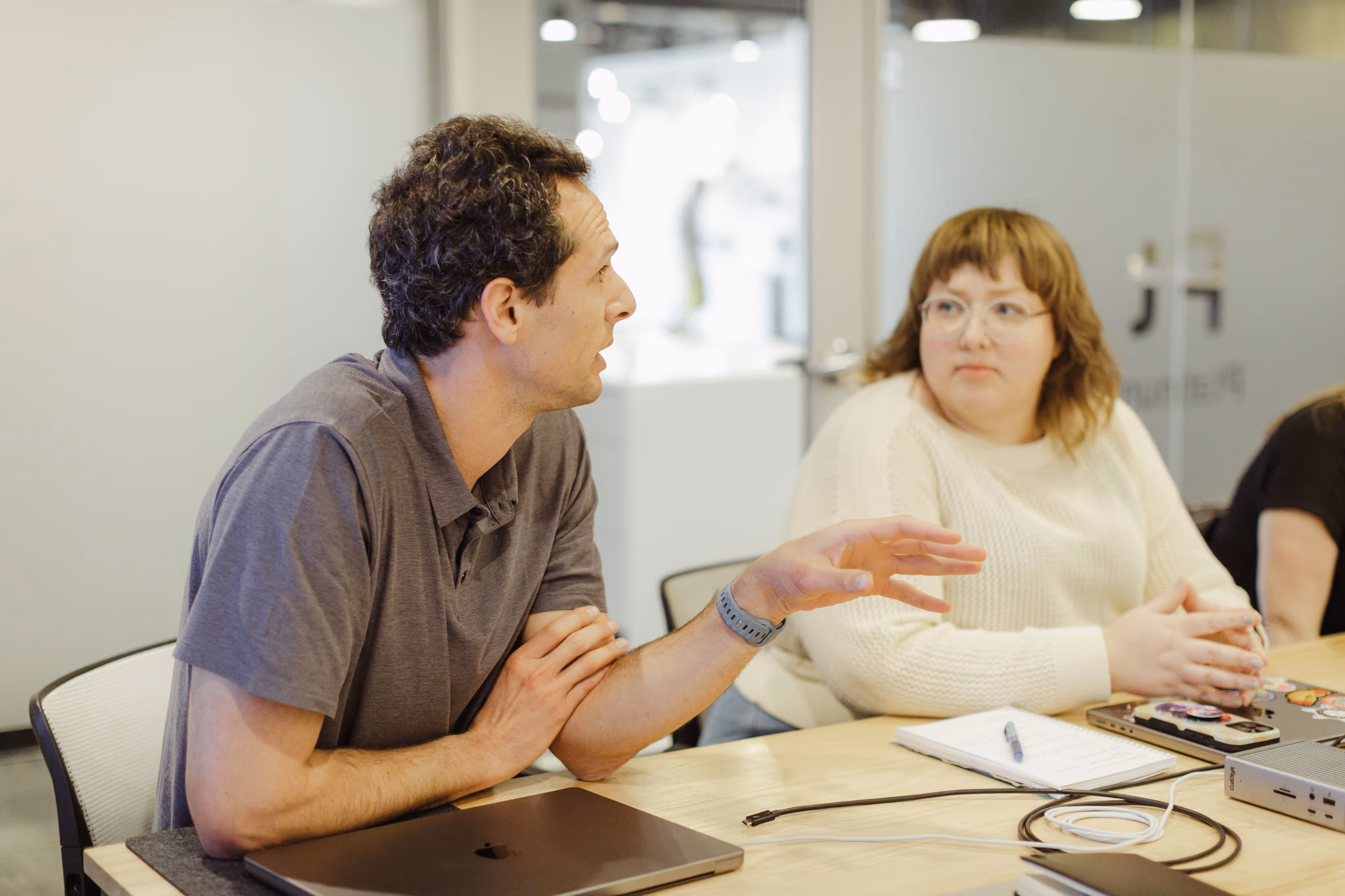 The Atomic Object team collaborates during a meeting, discussing software development and design.