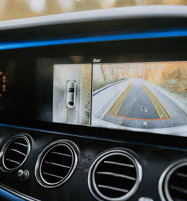Dashboard display showing a rearview camera and sensor graphic in a vehicle for computer vision applications.