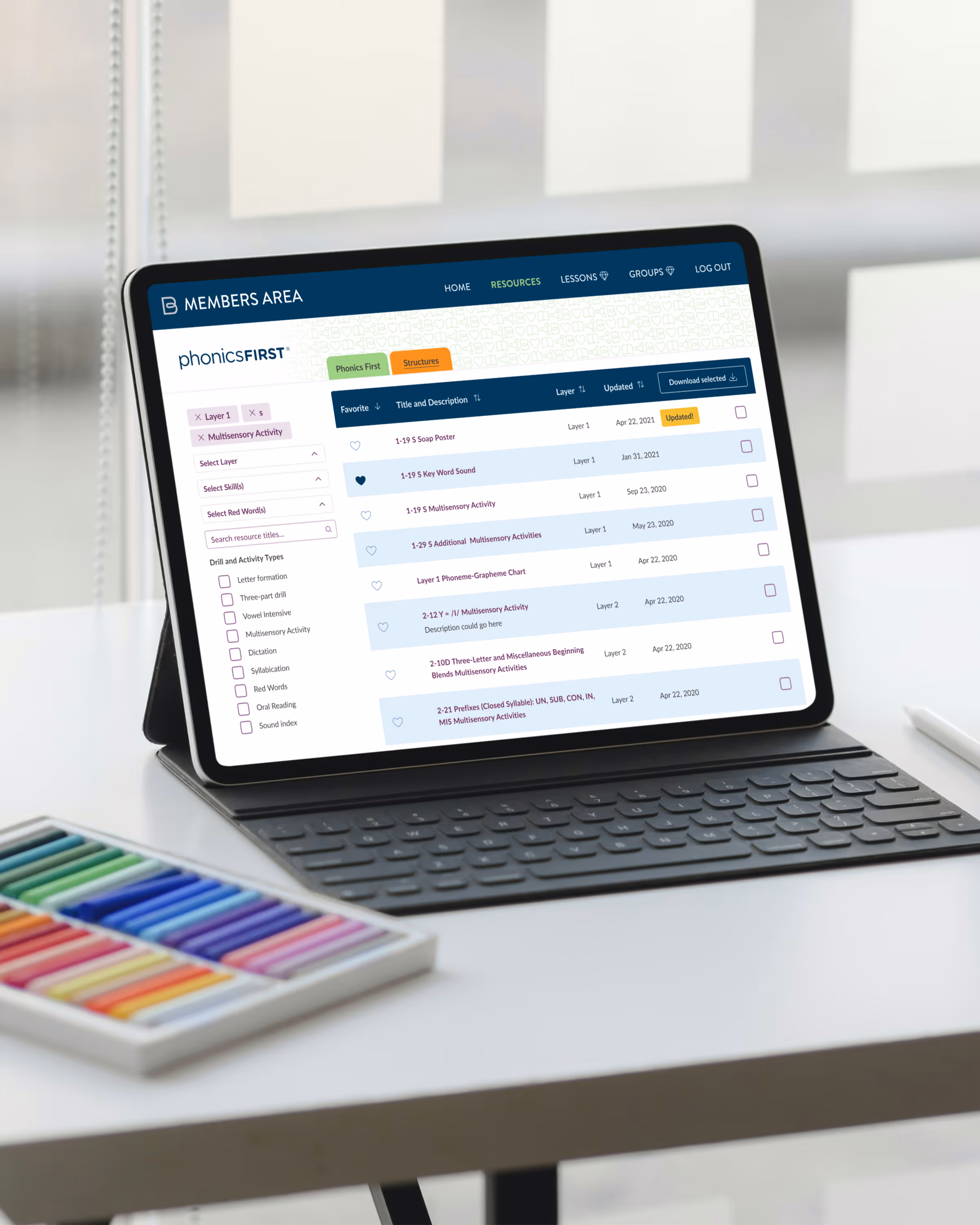 Tablet with keyboard displaying a phonics learning platform showing multisensory activities and drill options.