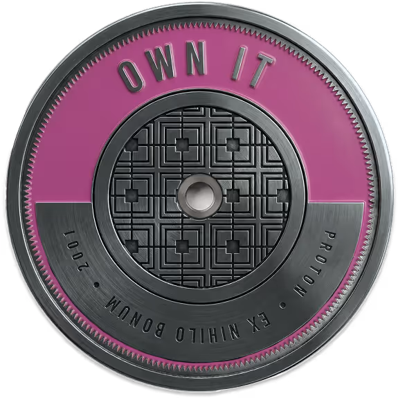 A metallic token inscribed with the Atomic Object value, "OWN IT"