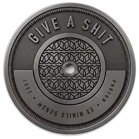 A metallic token inscribed with the Atomic Object value, "GIVE A SHIT"