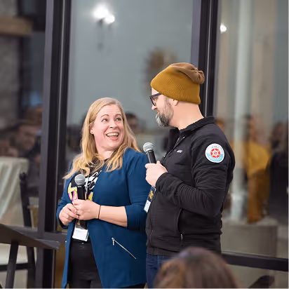 Atomic Object team members engage in a lively discussion during a presentation at a team event.