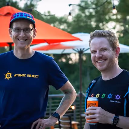 Atomic Object team members enjoying a social moment outdoors, engaging and building community.