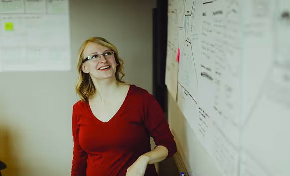 An Atomic Object team member engages in a collaborative brainstorming session with whiteboard notes.
