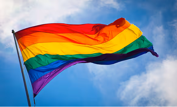 A pride flag waving in the sky, symbolizing diversity and inclusion at Atomic Object.