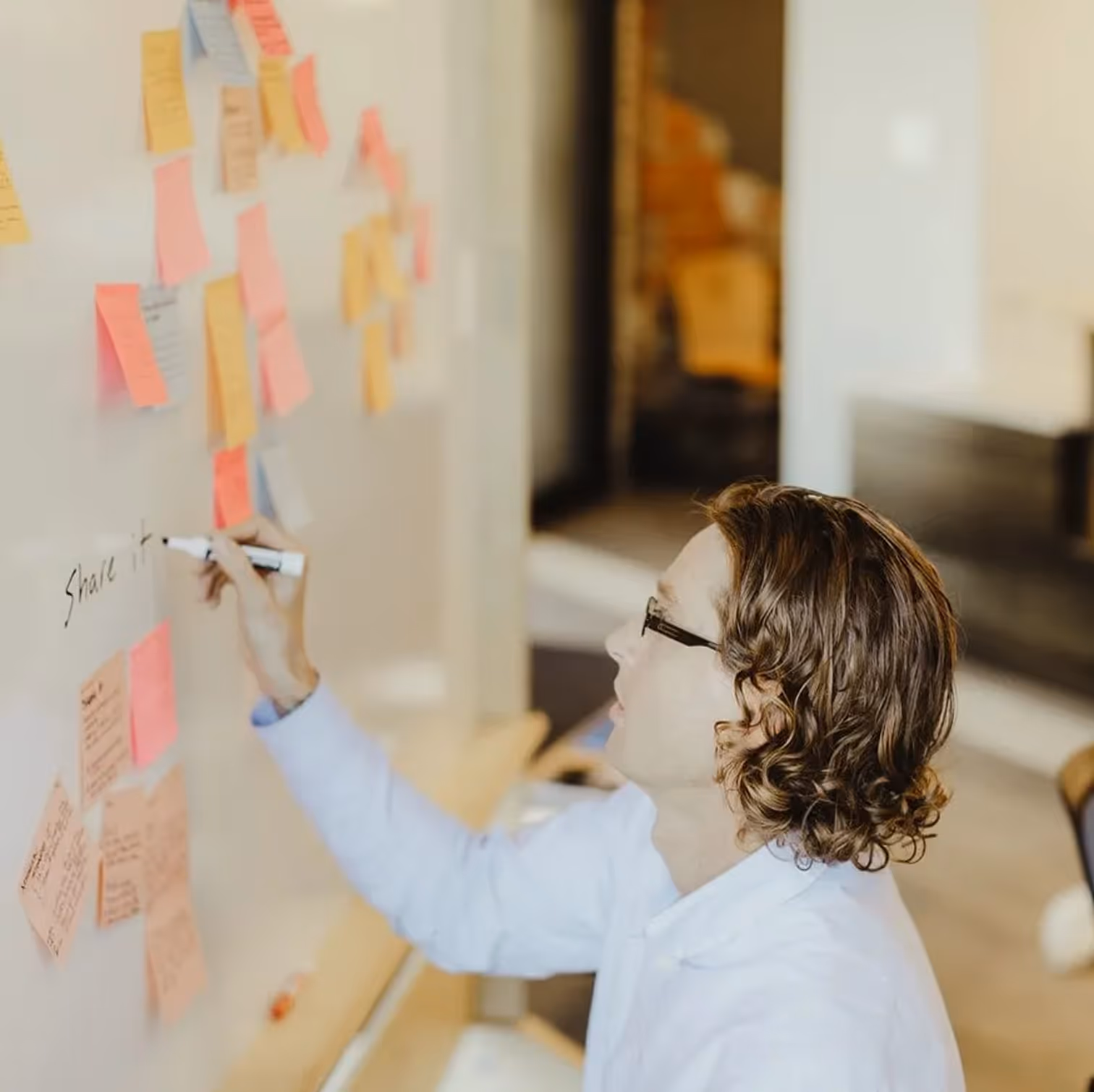 Atomic Object team collaborates on a project, discussing software development with sticky notes on a whiteboard.