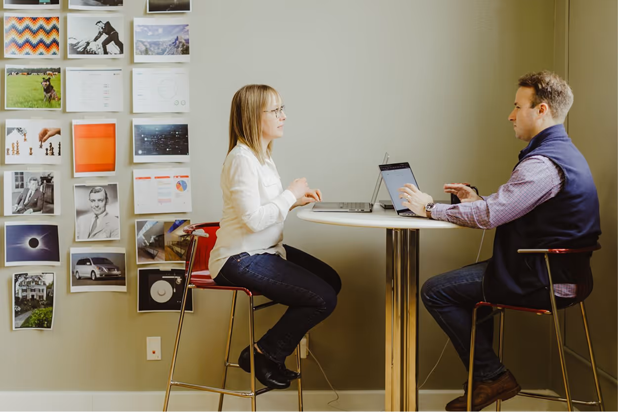 Atomic Object team discusses project budgeting at a table in a modern office setting, focusing on software development.