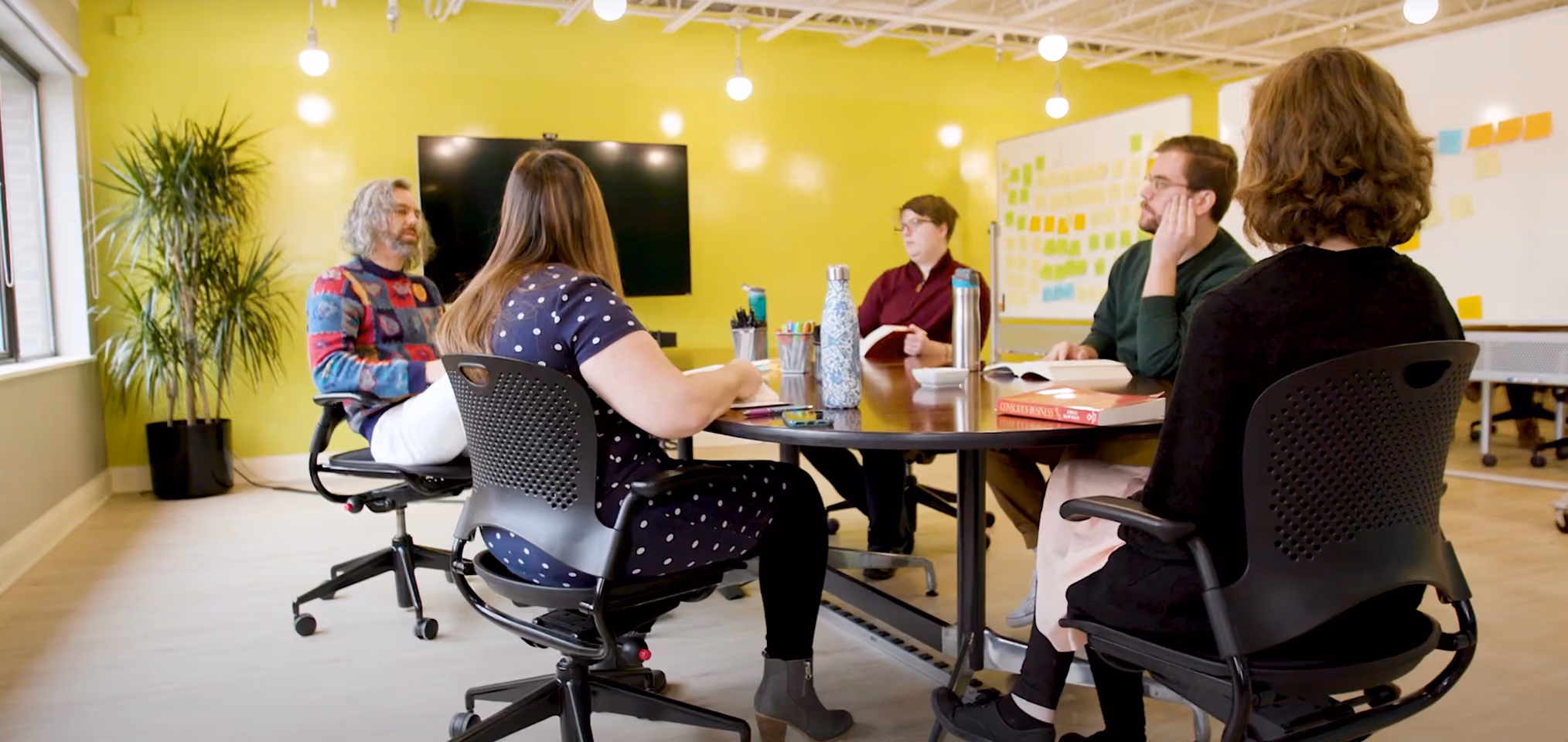 A team meeting in a modern office where participants discuss software development for the Atomic Accelerator program.