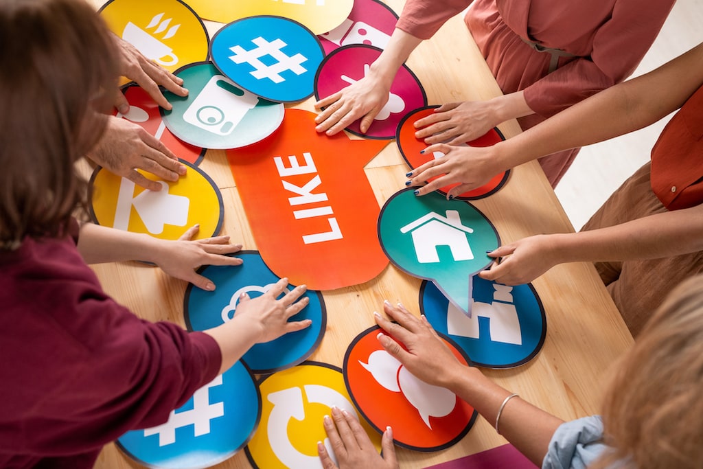 Image of several millennials collaboratively selecting designs for social media graphics, showcasing the importance of creating shareable visuals to elevate brand presence.