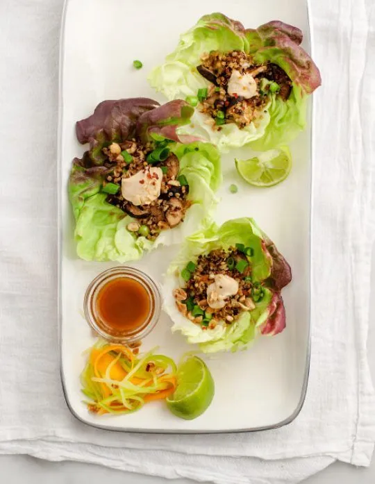 This may contain: lettuce wraps with chicken and sauce on a white plate