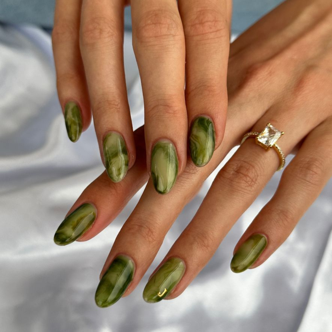 Long almond shaped green marble nails.