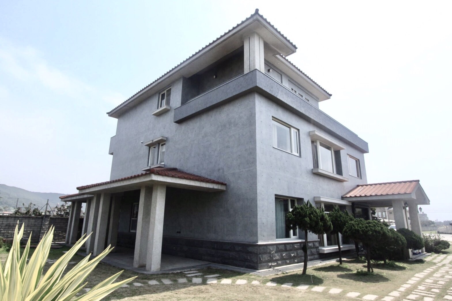 透天外牆設計採用後製清水模的淺灰色質感，讓住家輕易融入環境，且高機能的特性堅固耐用