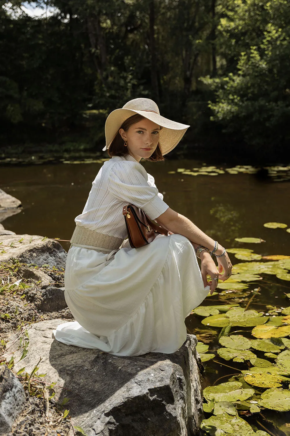 Photographie d'une modèle femme pour son book au bord d'une rivière, avec des nénuphars.