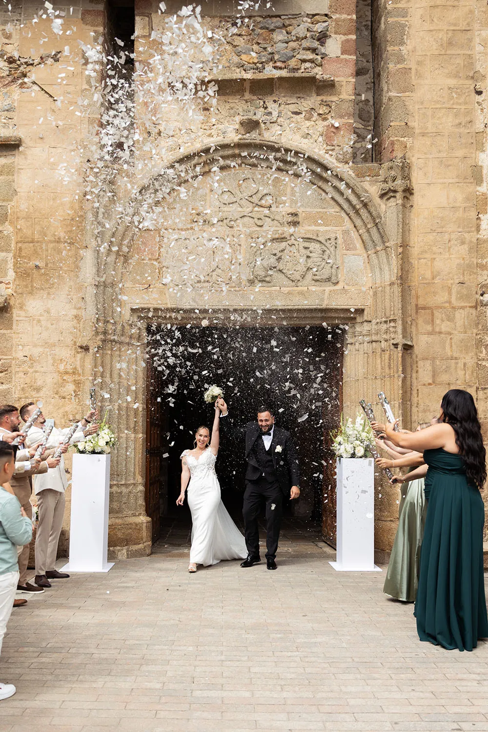 Photographe de mariage à Nantes et Paris. Sortie d'église avec confettis blancs