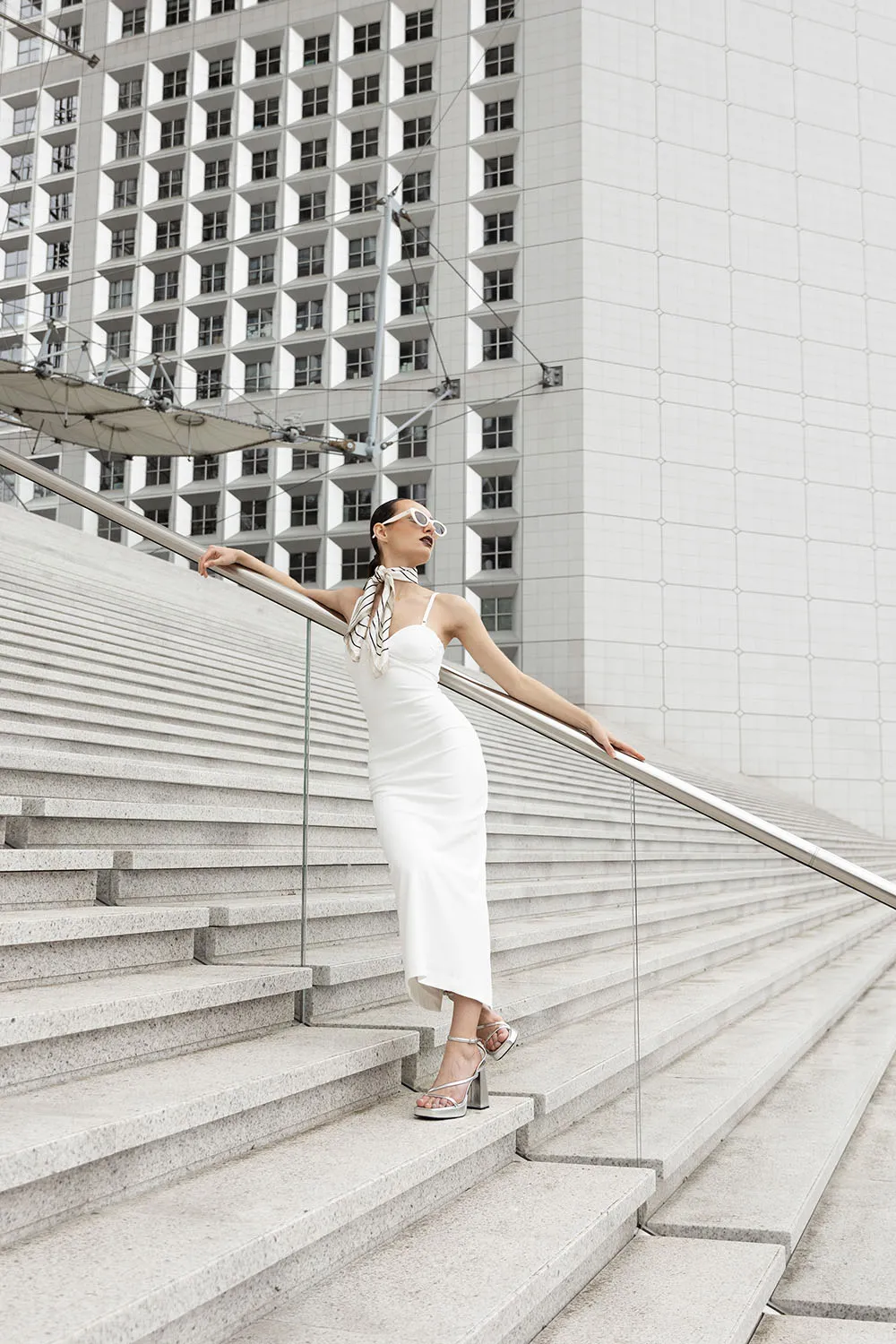 Photographie de portrait artistique pour un book minimaliste d'une modèle, réalisée sur les marches de La Défense à Paris.