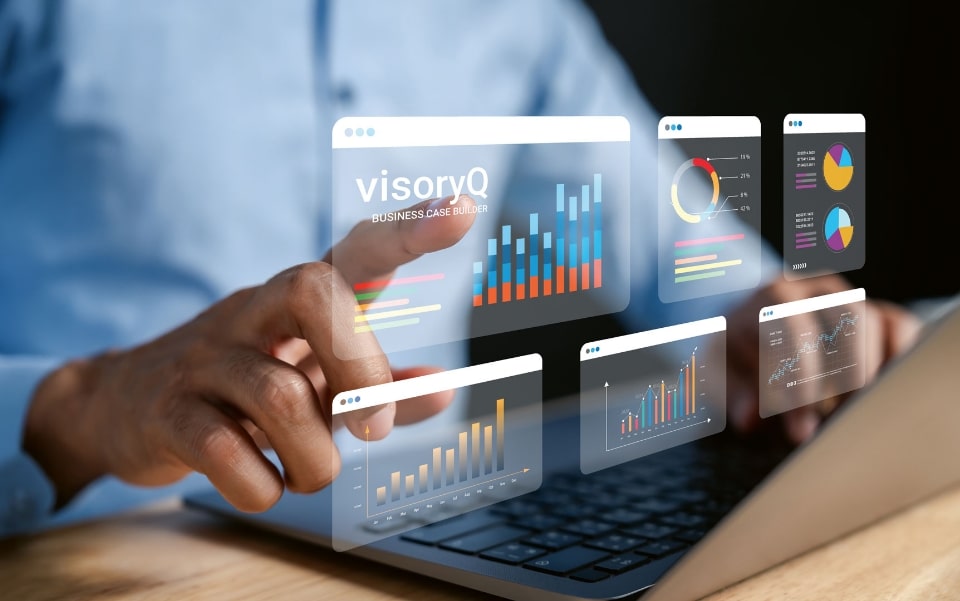 Person interacting with floating digital business charts and graphs above a laptop keyboard.
