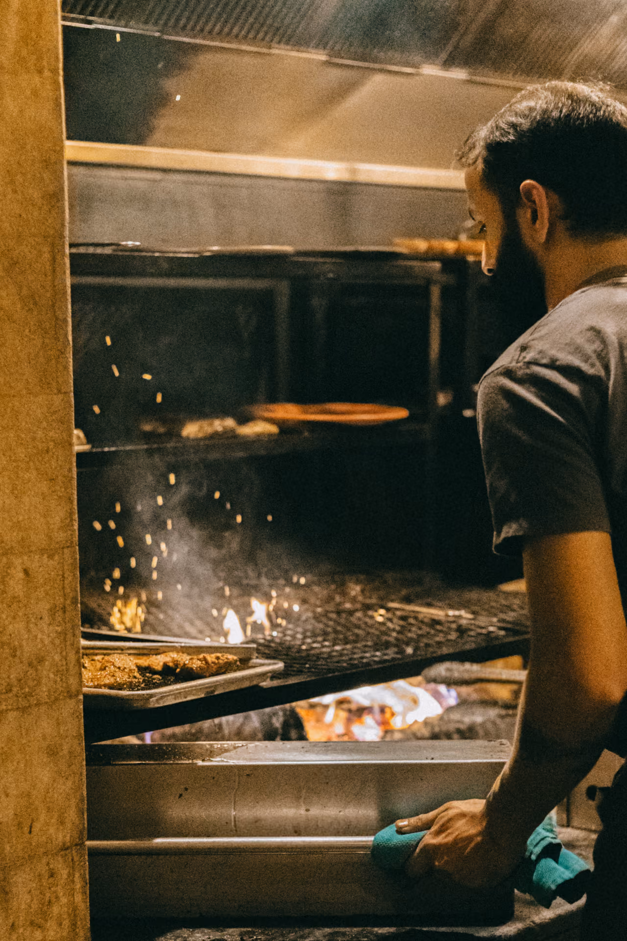 Man cooking in a restaurant on top of charcoal and fire