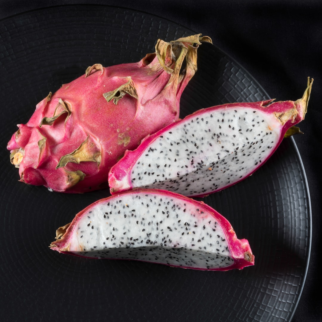 Dragon fruit growing on a cactus plant.
