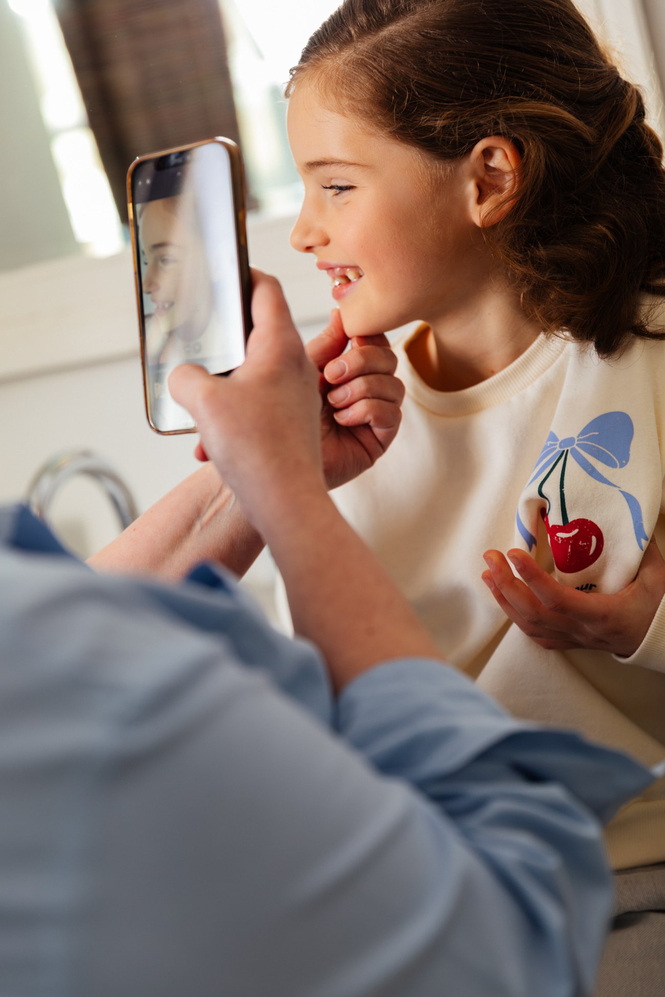 Een mama fotografeert de huid van haar lachende dochter met de Skindr-app