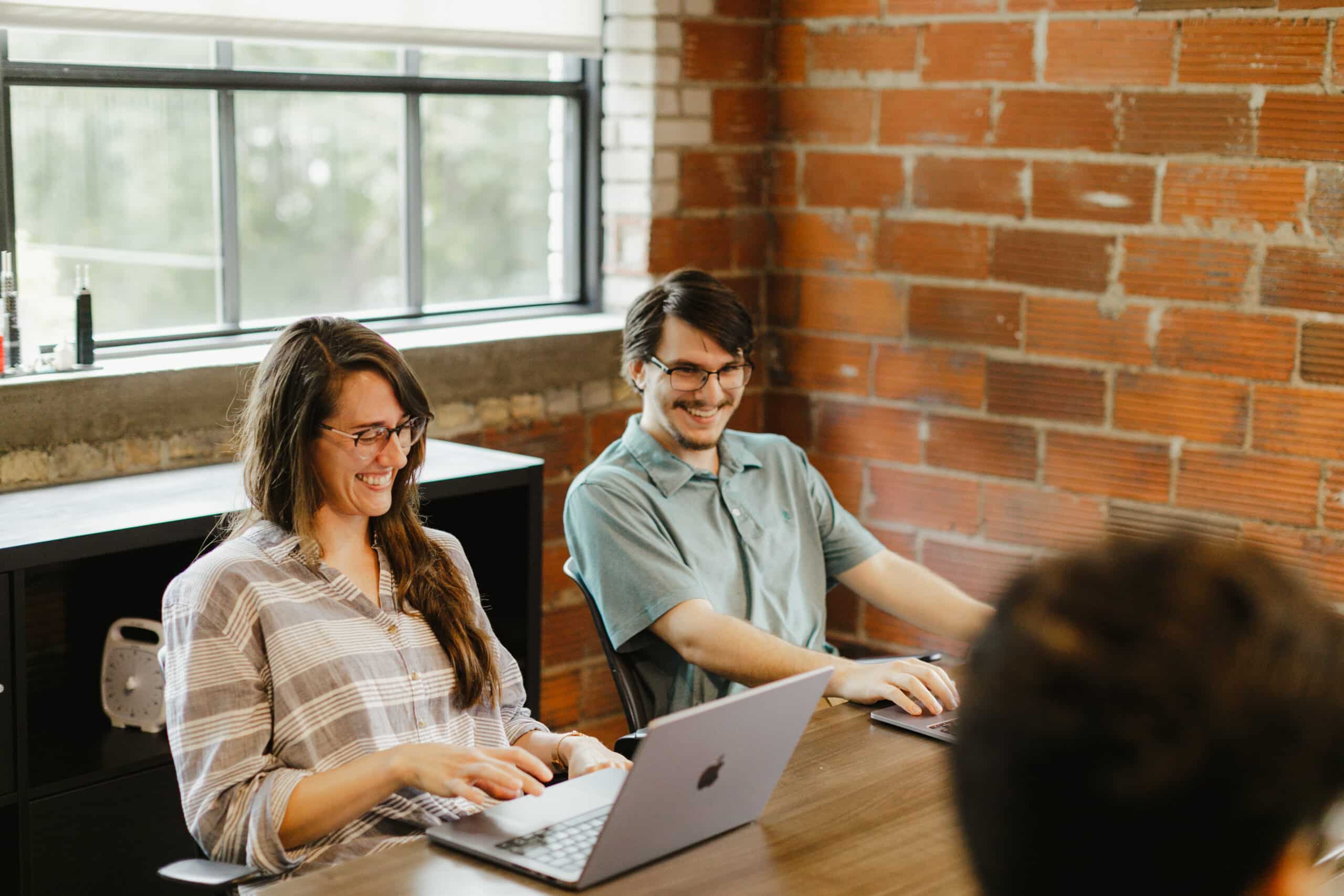 Pictured is author Meghan Harris smiling during a meeting with co-workers. Post title: Git Subtree and Other Tips for Migrating a Repo