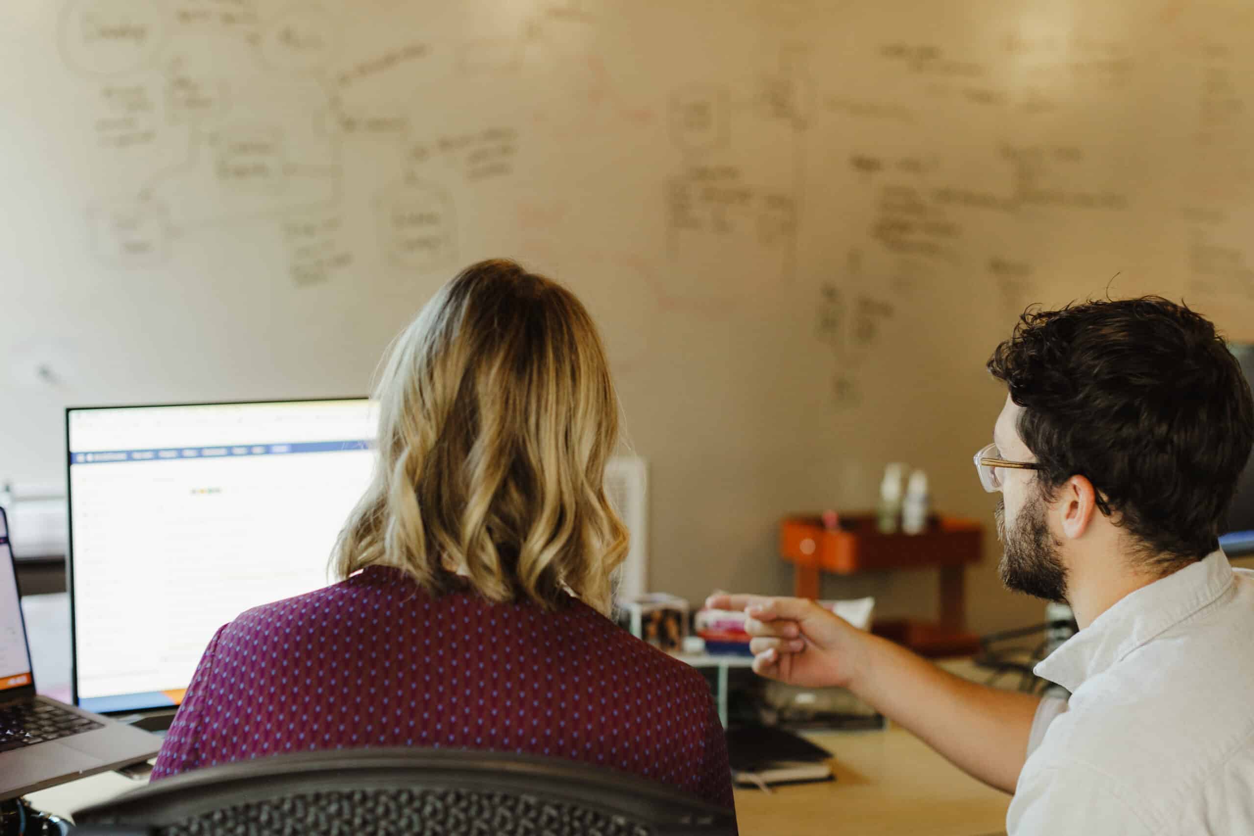 Two developers looking at a monitor together. Post title: CancellationToken in C# - Pitfalls and Winning Patterns