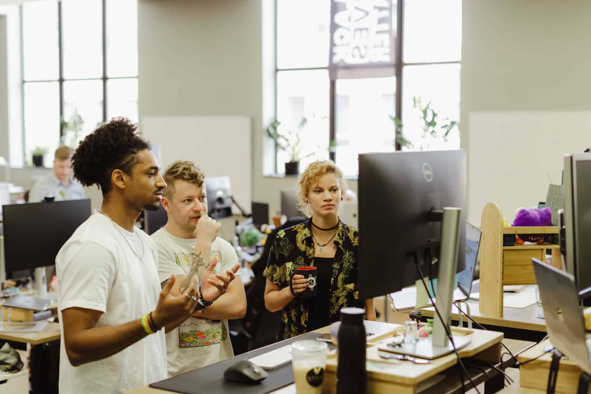 Author Jacob Williams talks with coworkers at Atomic Object. Post title: FAQs about the Atomic Experience: Being A Maker