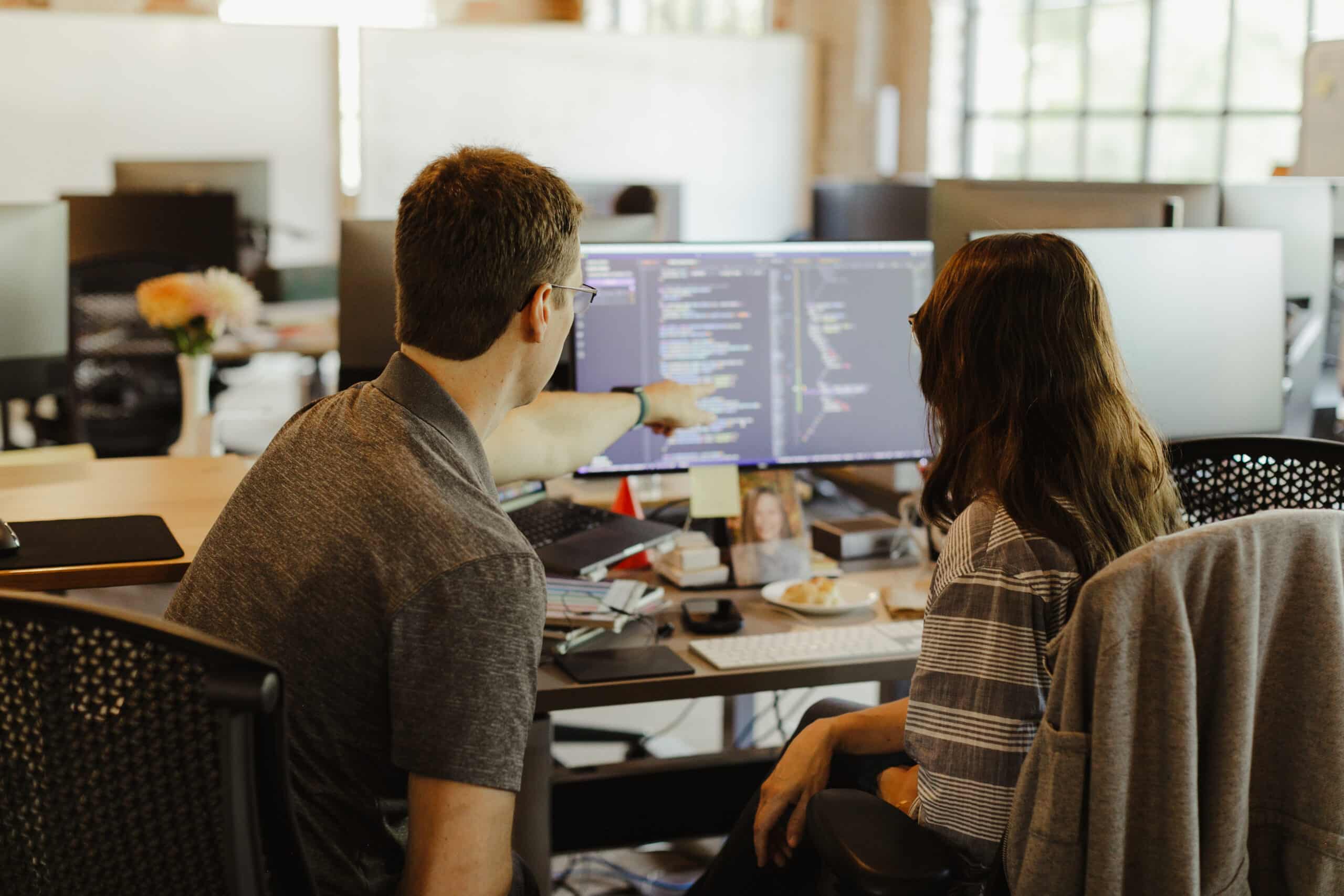 A developer gestures at a monitor while talking with a colleague. Post title: If You Think AI Made You a 10x Developer, You Need to Pair Program More