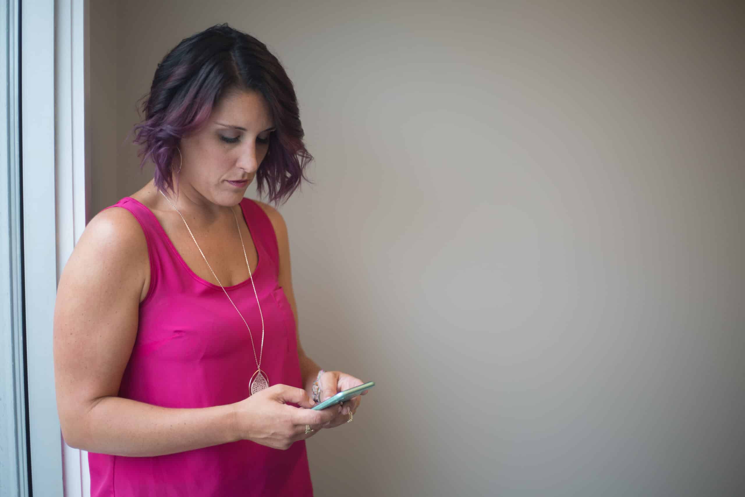 A public domain photo of a woman looking at her smartphone.