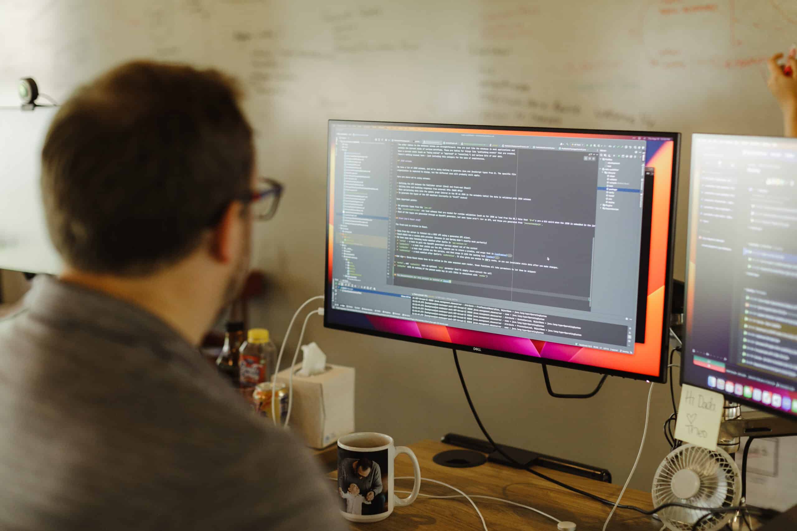 Pictured is a developer looking at a screen full of code. Post title: Pencils, Not Stencils: A Better Way to Prune Git Branches: fzf and a Tiny Loop