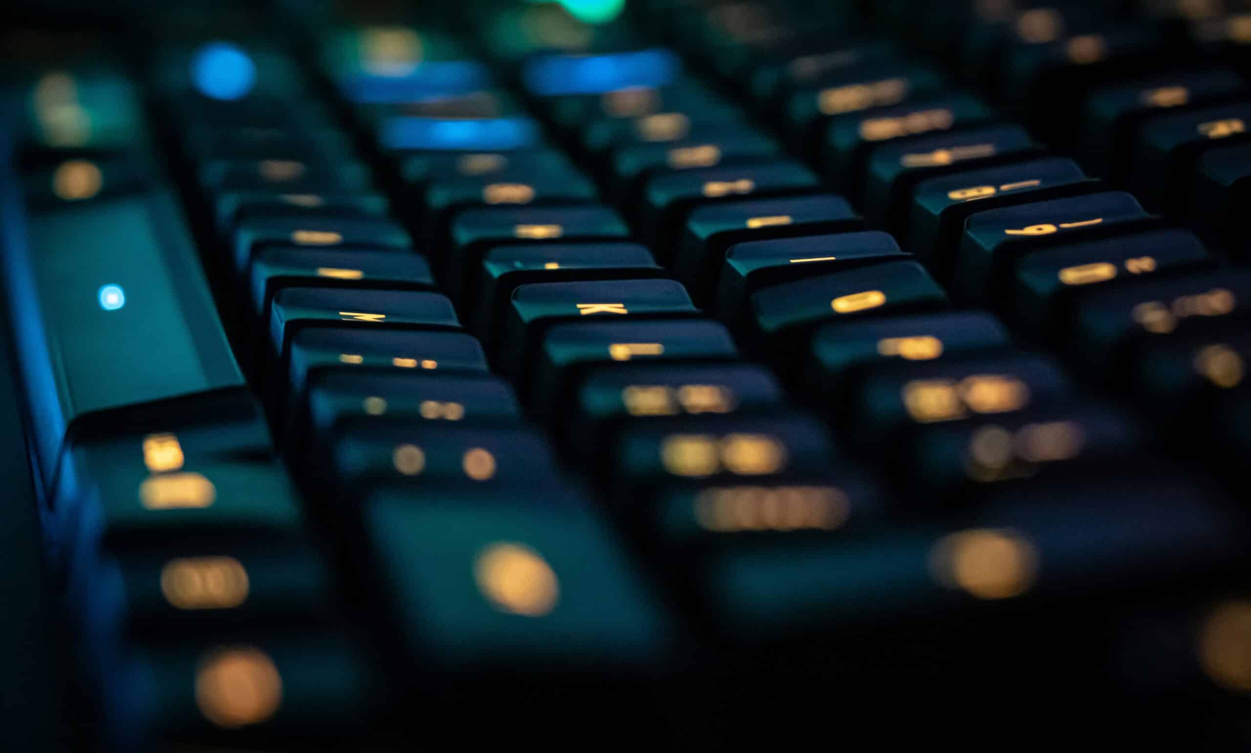 Close-up of a backlit computer keyboard. Post title: Tickets to Commits: What IT Work Taught Me About Writing Code