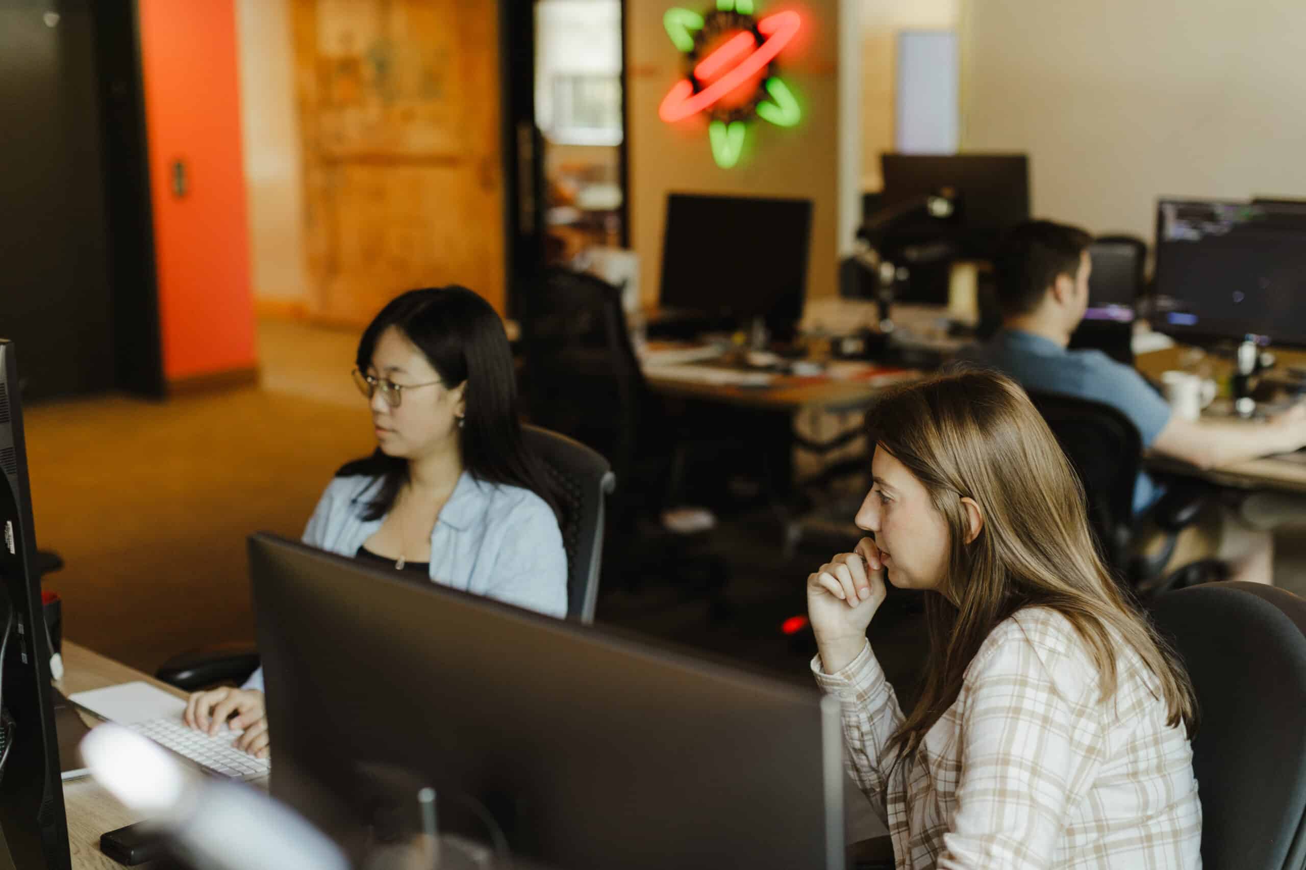 Author Lydia Cho looks at a monitor with a co-worker. Post title: Traditional Coding vs. Low Code
