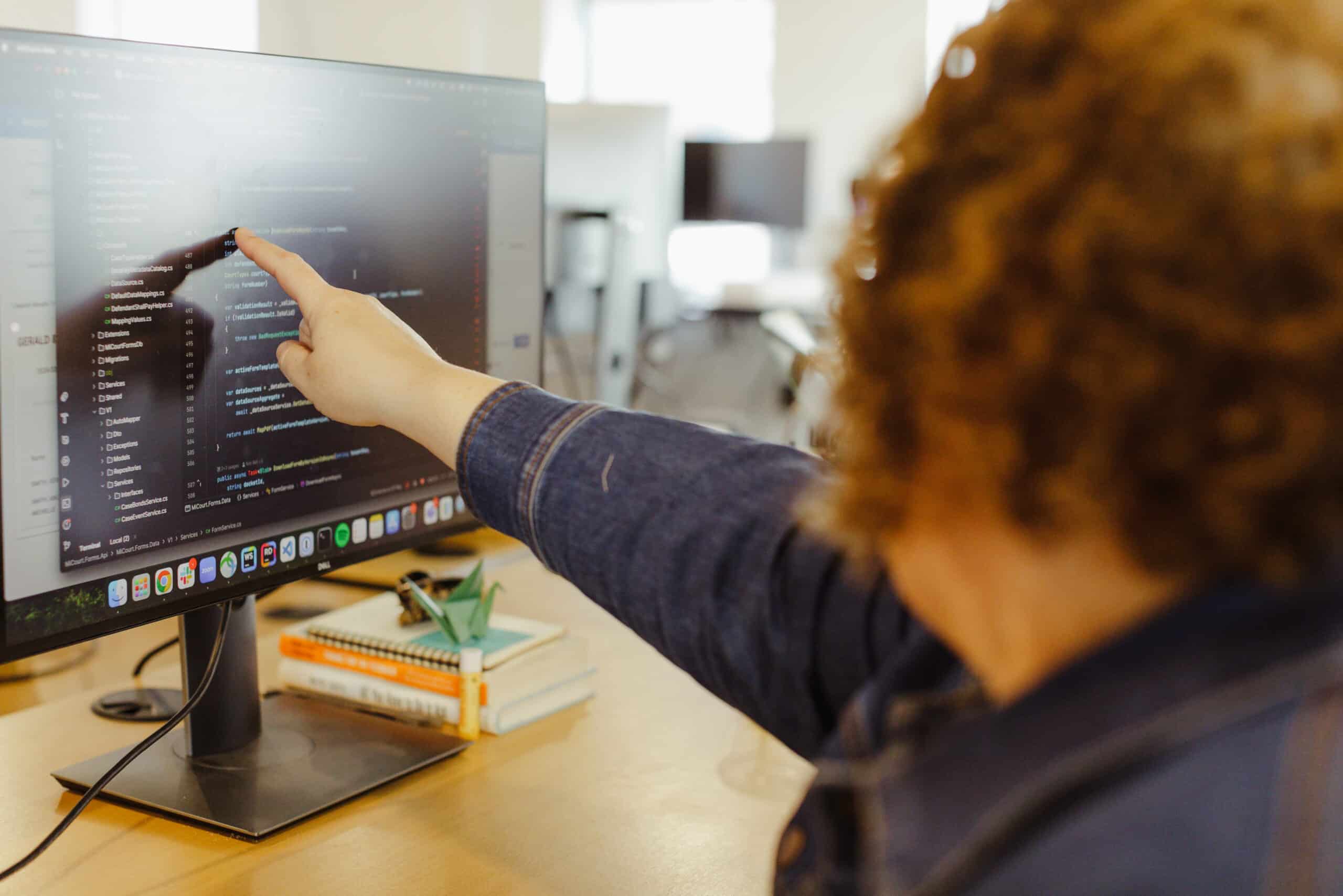 Author Kealy Williams points at a monitor. Post title: When Code Becomes Cheap, What's Left?